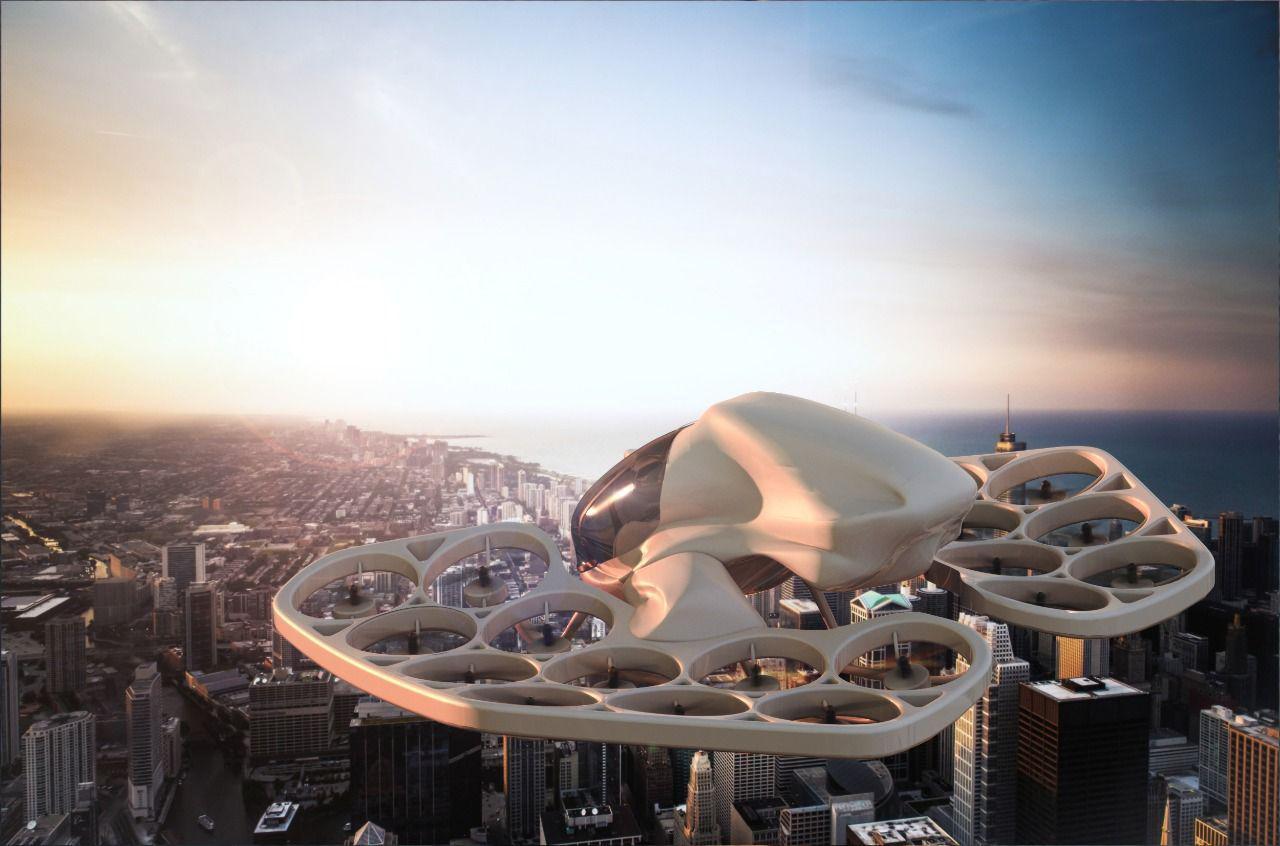 Three-quarter aerial view of the Flyka F1 eVTOL flying above a city, showing the ring of ducted-fan motor units